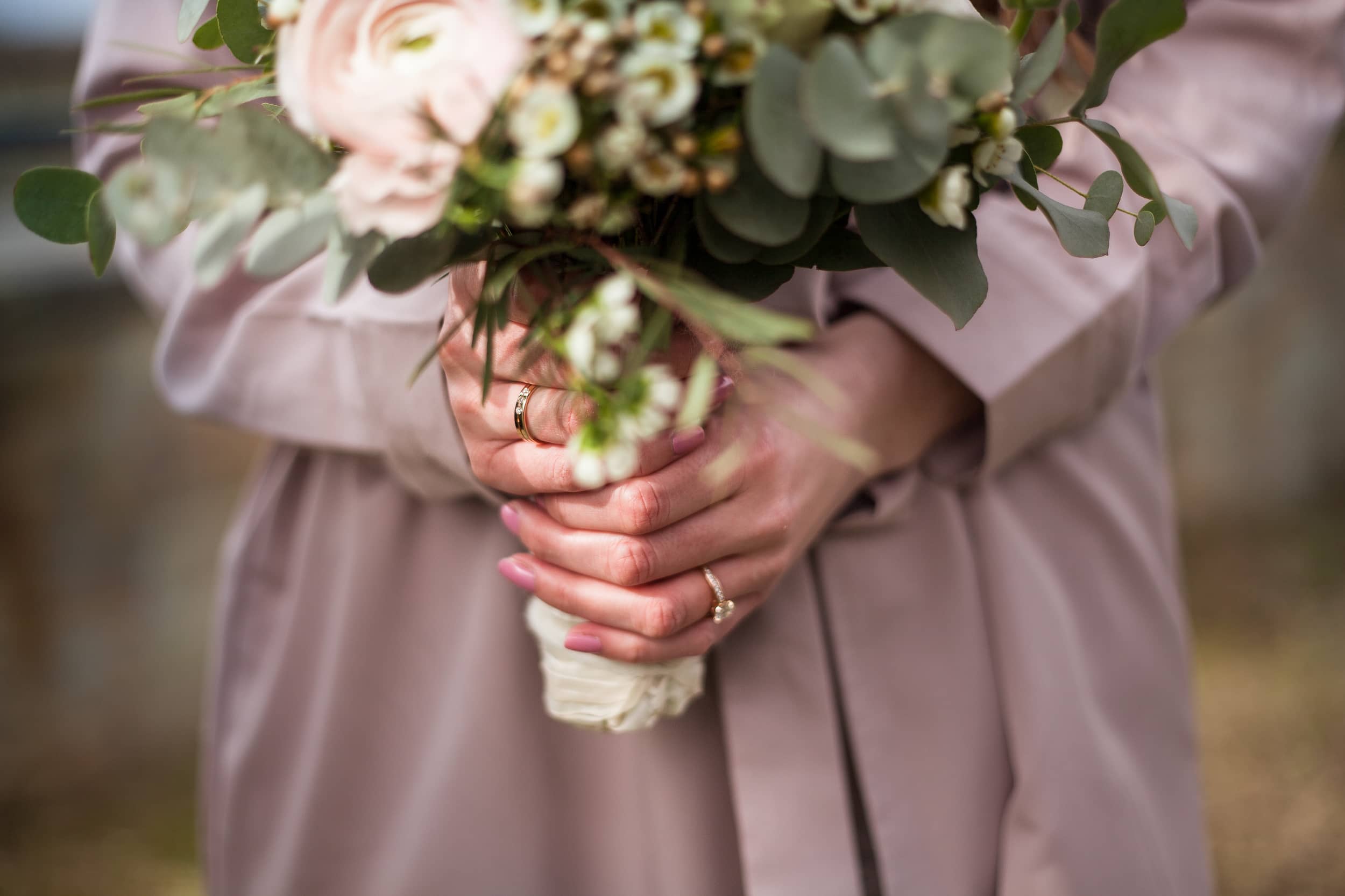 nervöse Braut umklammert Brautstrauß mit beiden Händen